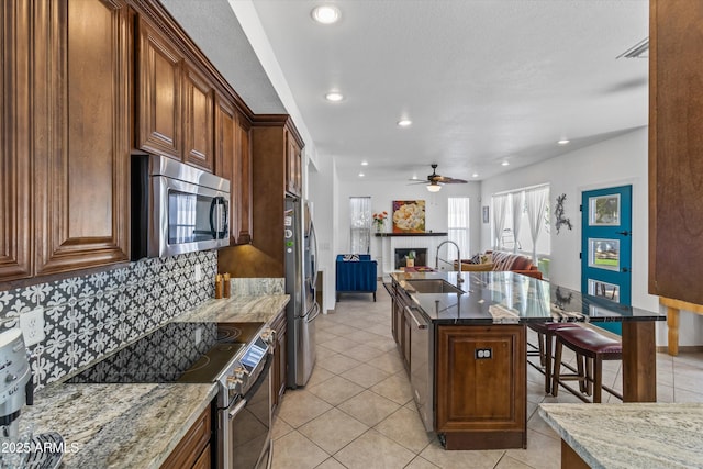 kitchen featuring dark stone countertops, sink, and appliances with stainless steel finishes