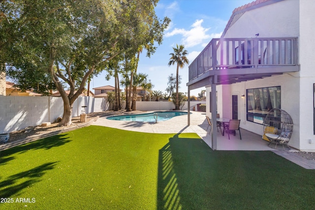 view of yard with a balcony, a fenced in pool, and a patio area