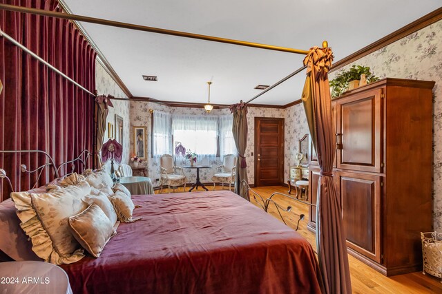 bedroom featuring crown molding and light hardwood / wood-style flooring