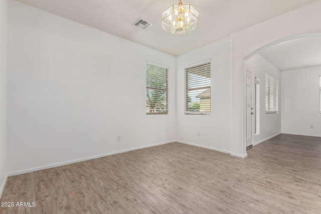 16215 W Durango St, Goodyear, AZ 85338 - spare room with wood finished floors, arched walkways, a chandelier, and baseboards