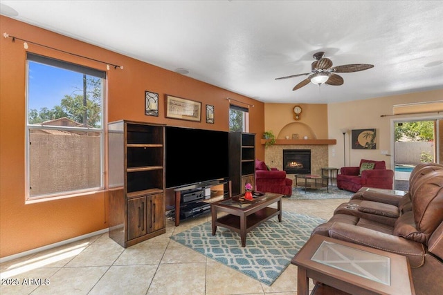5212 S Monte Vista St, Chandler, AZ 85249 - living room featuring ceiling fan, light tile patterned floors, and a warm lit fireplace