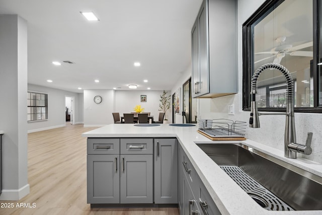 kitchen with ceiling fan, a sink, gray cabinetry, a peninsula, and recessed lighting