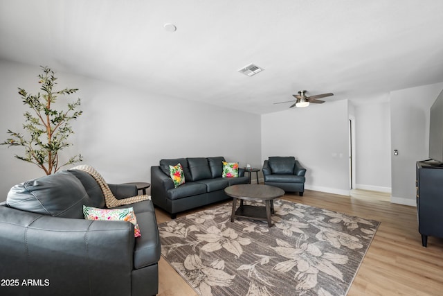 living area featuring baseboards, ceiling fan, visible vents, and wood finished floors