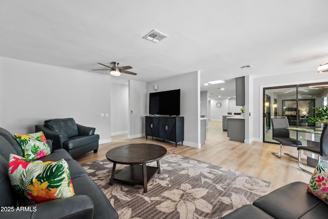 living area with ceiling fan, visible vents, and light wood-style flooring