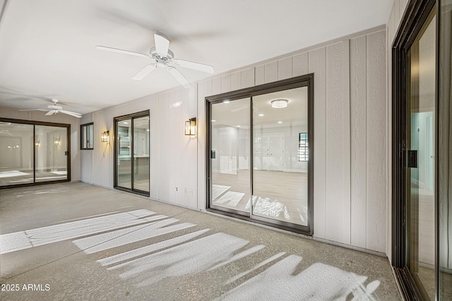 interior space with carpet flooring and ceiling fan