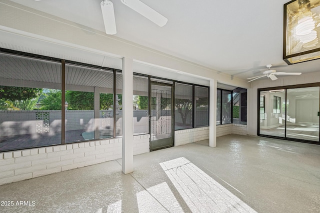 unfurnished sunroom with plenty of natural light and a ceiling fan