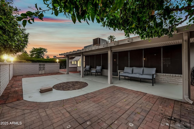 view of patio featuring outdoor lounge area, a fenced backyard, and a sunroom