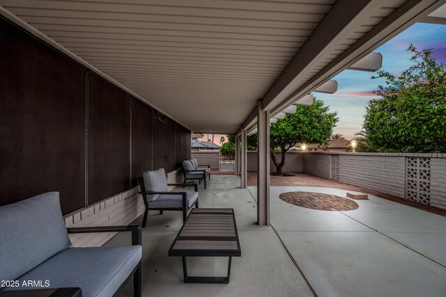 patio terrace at dusk featuring a fenced backyard