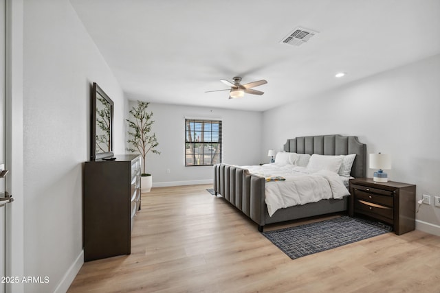 bedroom featuring baseboards, light wood-style flooring, and visible vents