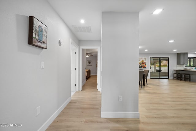 hall featuring visible vents, recessed lighting, light wood-style flooring, and baseboards