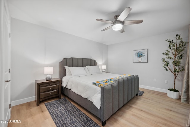 bedroom with a ceiling fan, baseboards, and light wood-type flooring