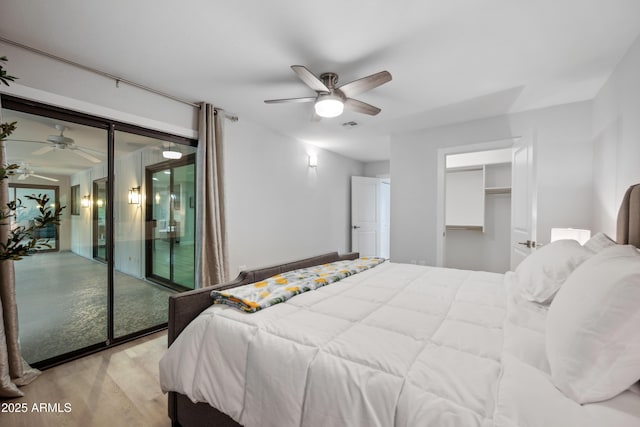 bedroom with ceiling fan, wood finished floors, and visible vents