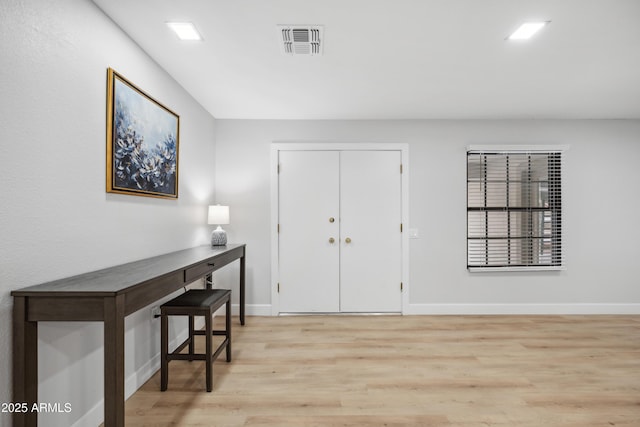 foyer with baseboards, light wood-type flooring, and visible vents