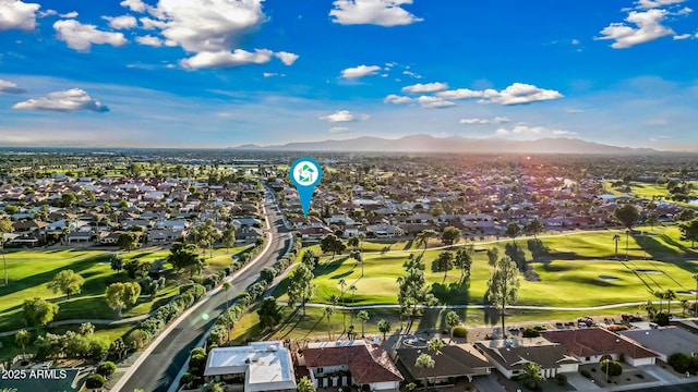 drone / aerial view with view of golf course, a residential view, and a mountain view