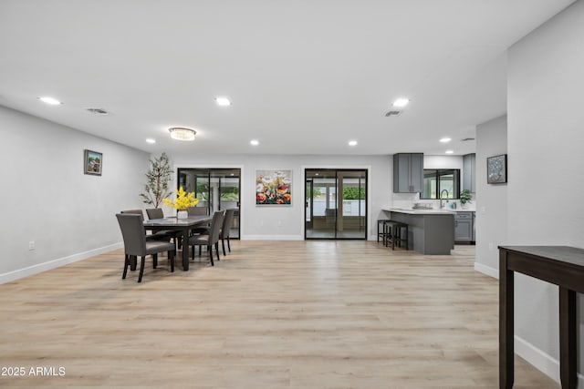 dining room featuring recessed lighting, baseboards, and light wood-style flooring