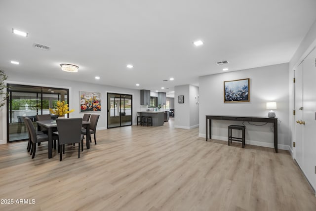 dining room with baseboards, visible vents, and light wood-style flooring