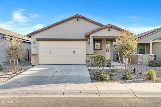 view of front of house featuring a tiled roof, concrete driveway, stucco siding, a garage, and stone siding