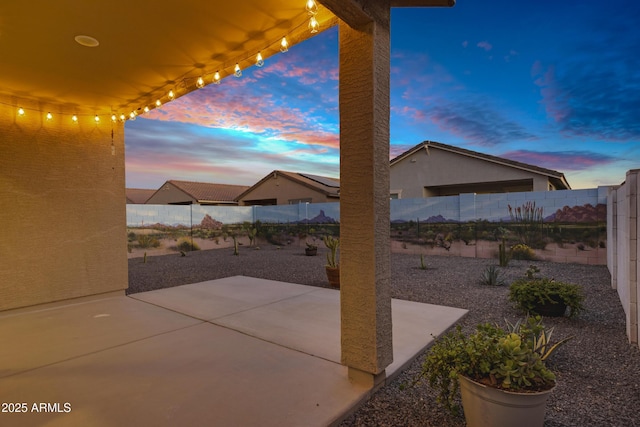 patio terrace at dusk with a fenced backyard