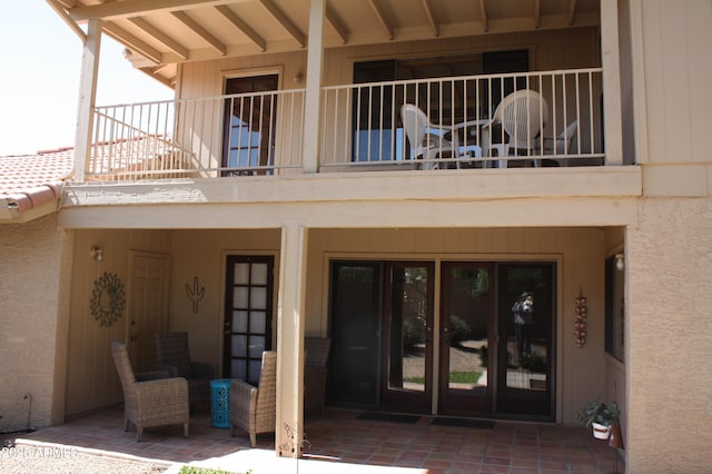 doorway to property with a balcony and stucco siding