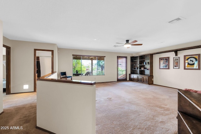 unfurnished living room with visible vents, light carpet, and a ceiling fan