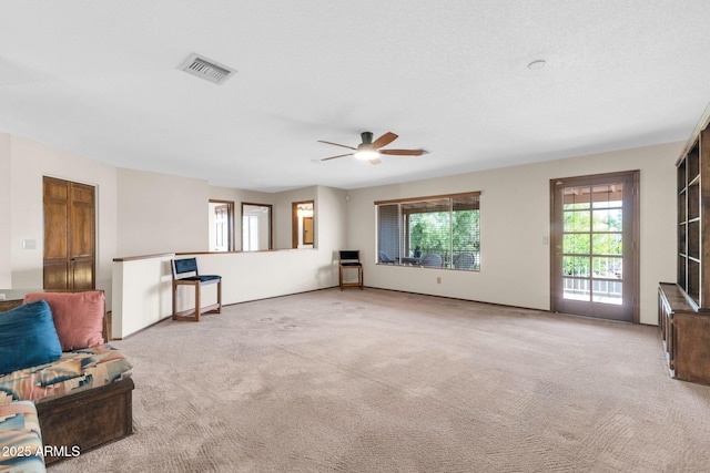 unfurnished living room with visible vents, carpet floors, and ceiling fan