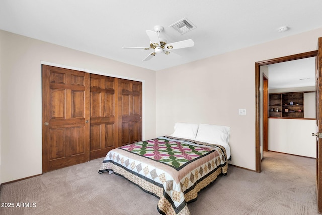 bedroom featuring light colored carpet, visible vents, a closet, and ceiling fan