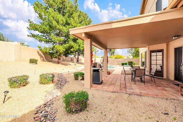 view of patio / terrace featuring a fenced in pool, a grill, and a fenced backyard