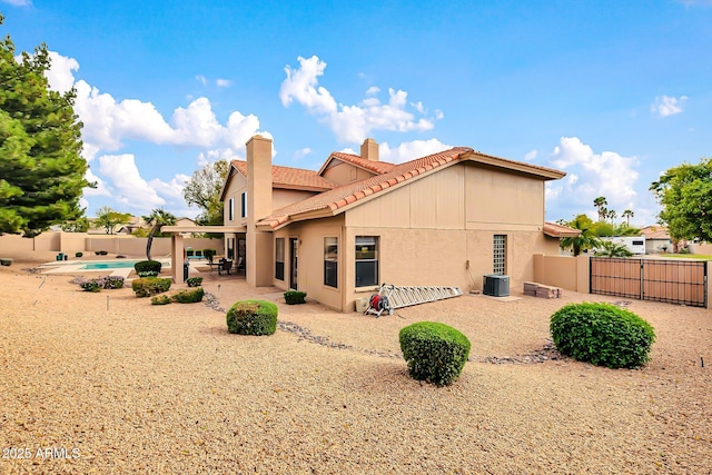 rear view of property with central air condition unit, stucco siding, a fenced backyard, a patio, and a gate