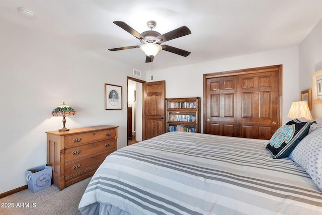 carpeted bedroom featuring ceiling fan and a closet