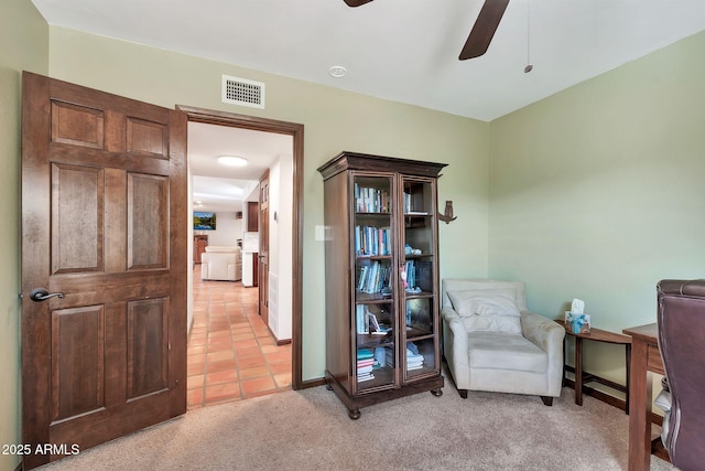 sitting room featuring ceiling fan and light colored carpet