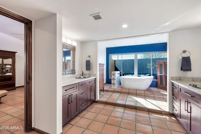 bathroom featuring tile patterned floors, a washtub, and a wealth of natural light