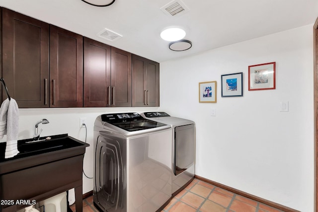 laundry area featuring cabinets, light tile patterned floors, sink, and washing machine and dryer