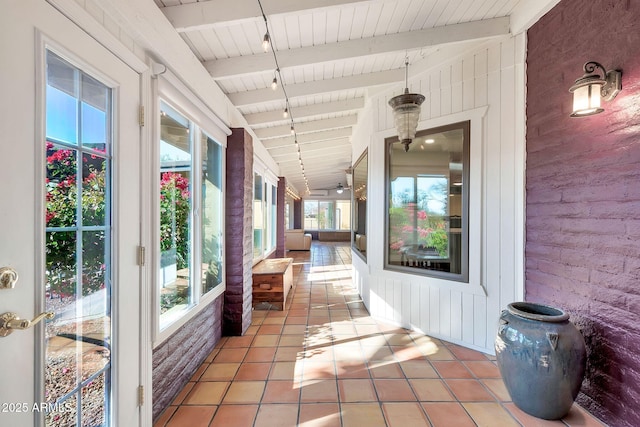 interior space featuring lofted ceiling with beams and plenty of natural light