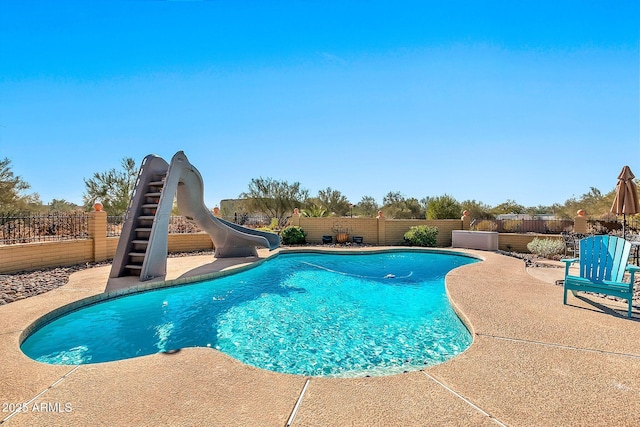 view of swimming pool with a patio area and a water slide