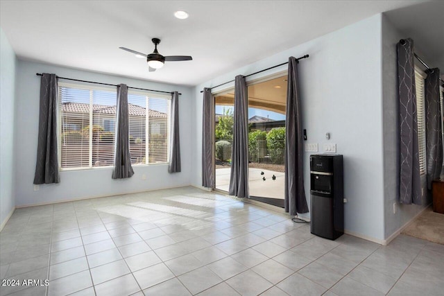 tiled spare room featuring ceiling fan