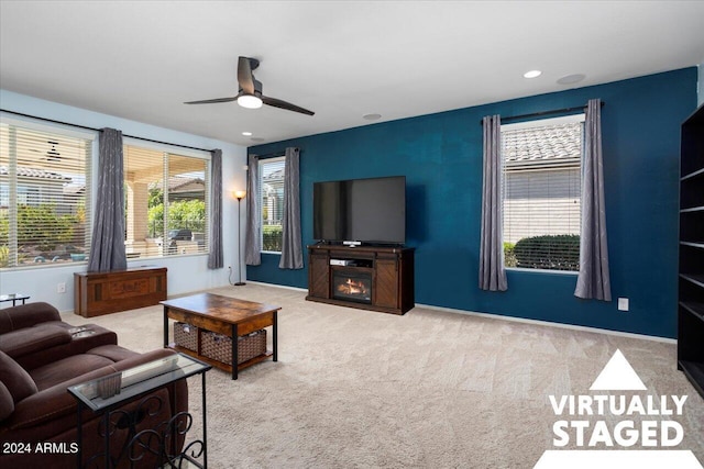 living room with light carpet, a fireplace, and ceiling fan