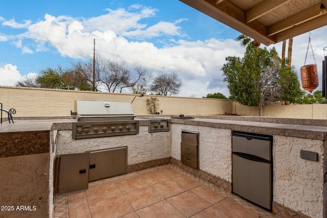 view of patio featuring area for grilling, a grill, and fence