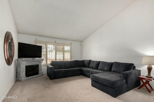 living area featuring light carpet, a fireplace with raised hearth, vaulted ceiling, and a textured ceiling