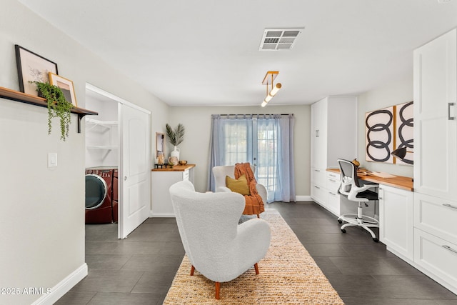 home office with visible vents, washing machine and clothes dryer, built in desk, and baseboards