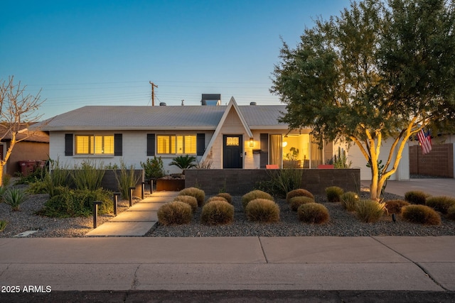 view of front of property with driveway, a fenced front yard, and a garage