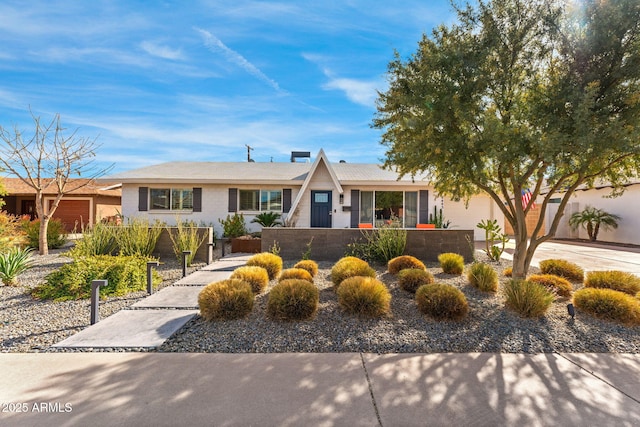 ranch-style home with a fenced front yard, concrete driveway, and a garage