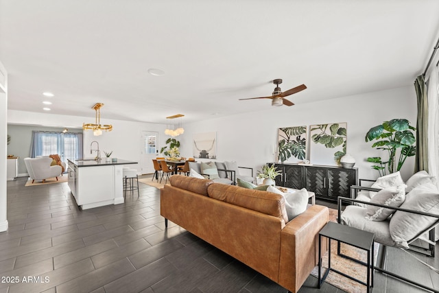 living area featuring ceiling fan with notable chandelier, wood finish floors, and recessed lighting