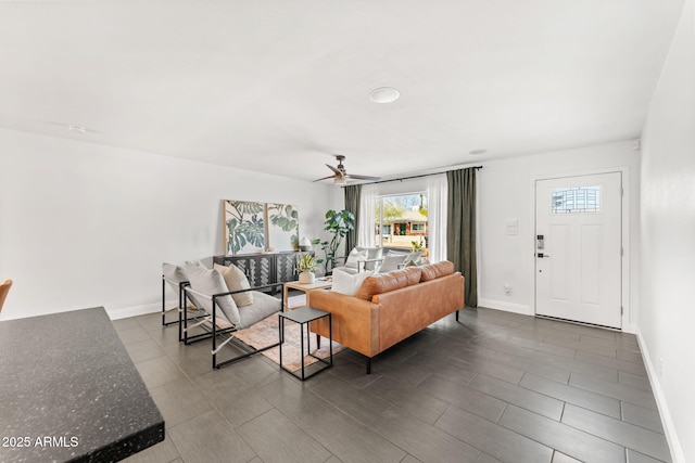 living area featuring ceiling fan and baseboards