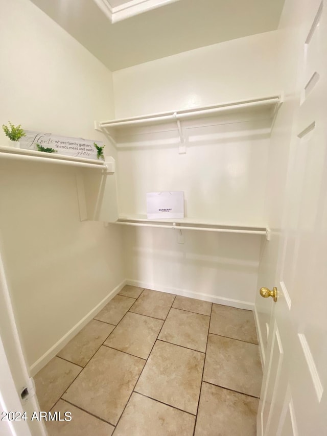 spacious closet with light tile patterned floors