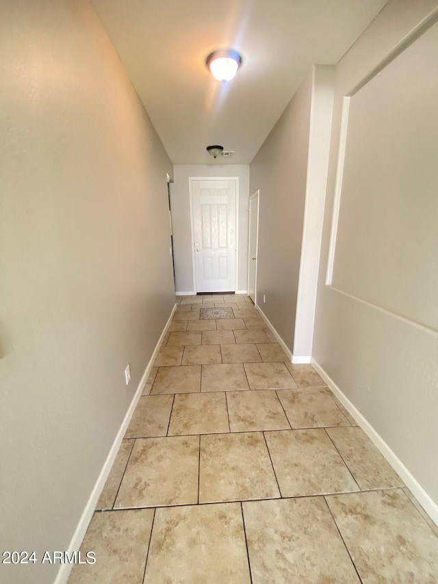 hall with light tile patterned floors