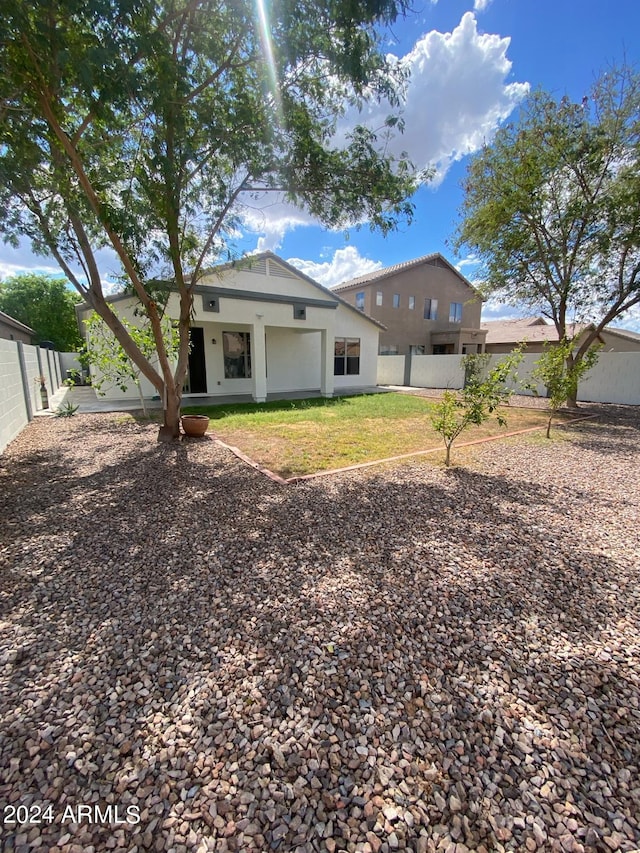 rear view of property featuring a yard