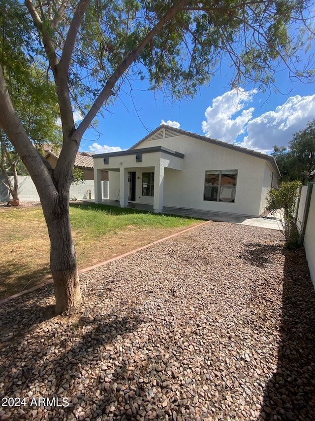 back of house featuring a lawn