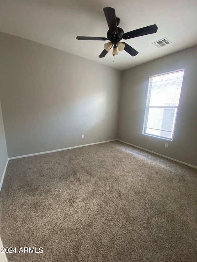 spare room featuring carpet flooring and ceiling fan