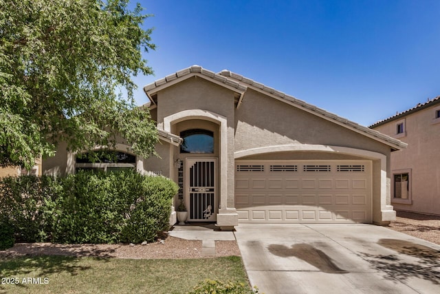 mediterranean / spanish home with an attached garage, driveway, and stucco siding