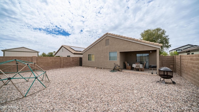 23941 N High Dunes Dr, Florence, AZ 85132 - rear view of property with a fenced backyard, a fire pit, stucco siding, and a patio area